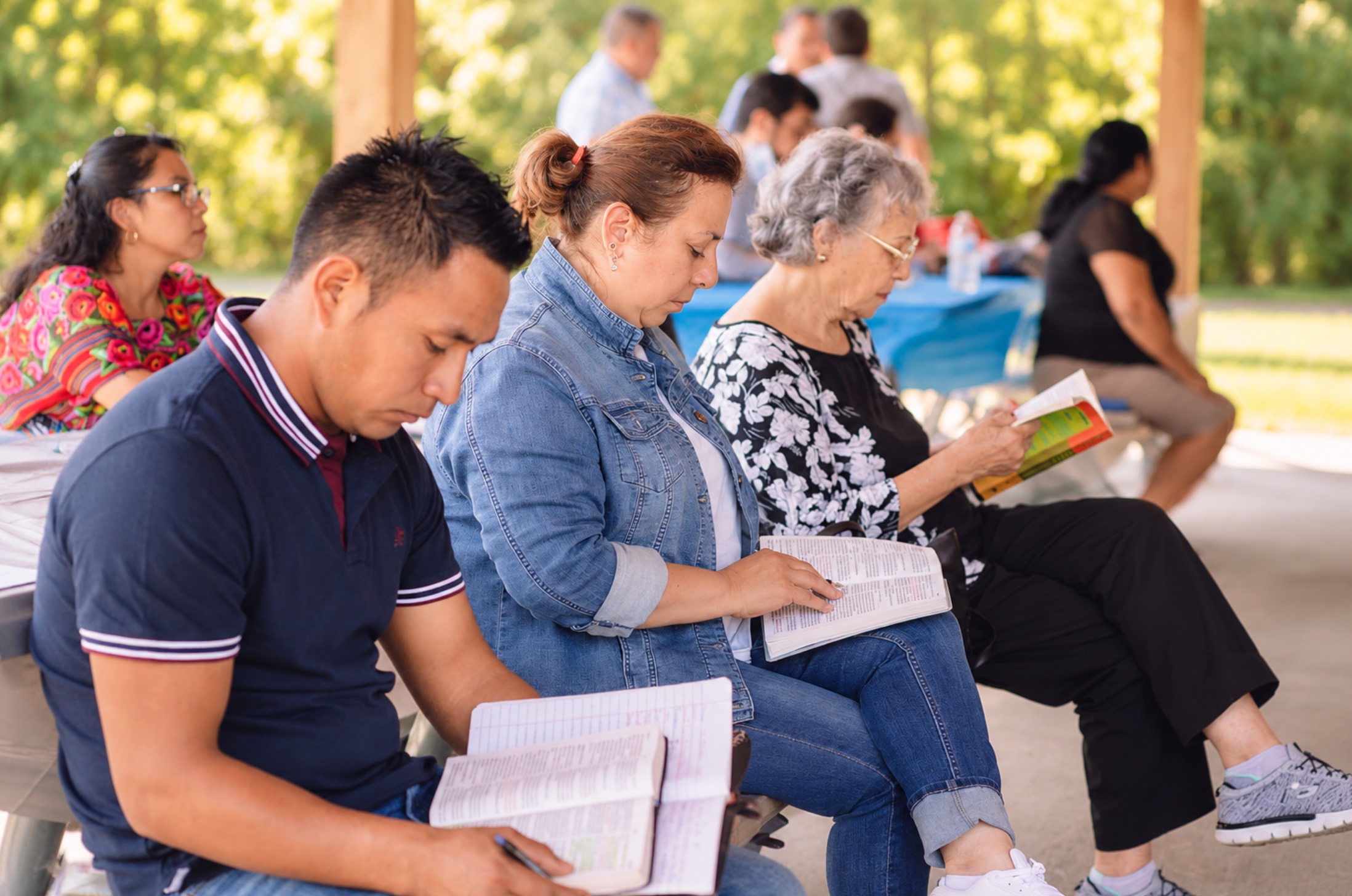 Miembros de la iglesia leyendo la Biblia juntos al aire libre